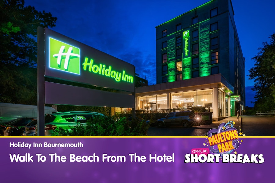 Holiday Inn Bournemouth lit up at night with message about walking distance to the beach.