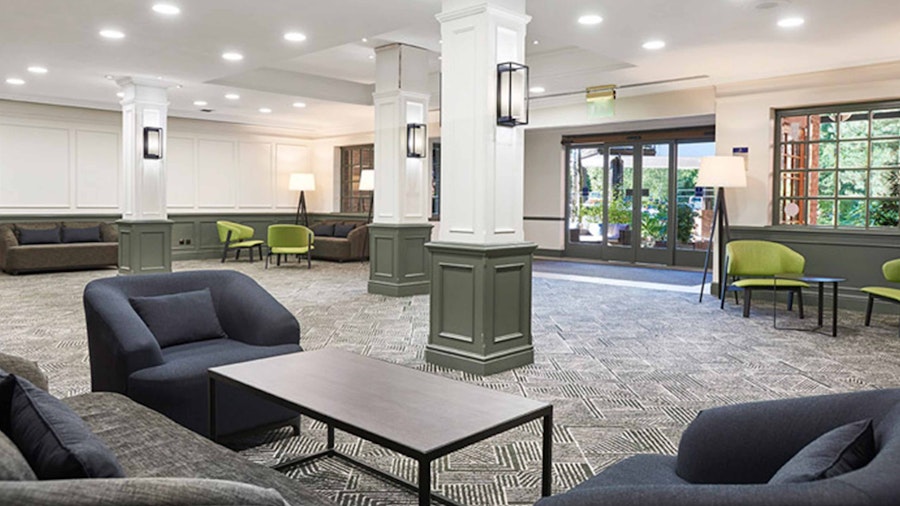 Hotel lobby with armchairs and coffee tables in a cool grey colour palette
