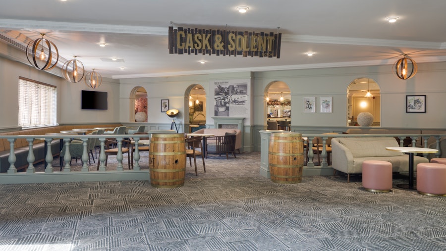 Hotel lobby with armchairs and coffee tables in a cool grey colour palette